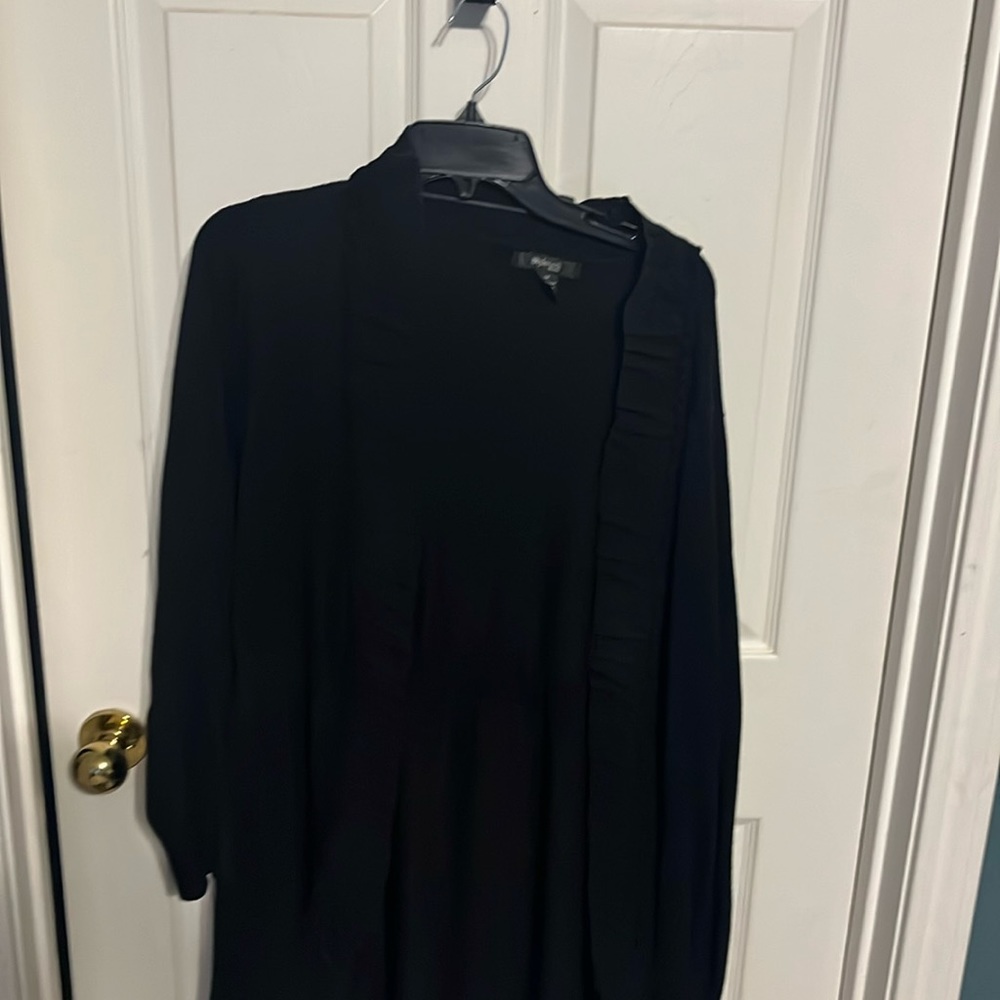 Black sweater with ruffle around the edge.